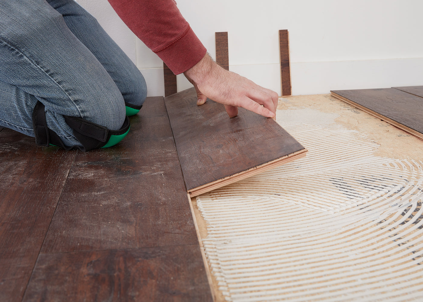 Flooring installer installing glue down hardwood flooring