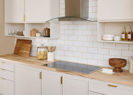 Kitchen with white tile backsplash and butcher block countertop