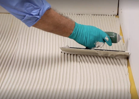 Spreading white thinset mortar with textured trowel